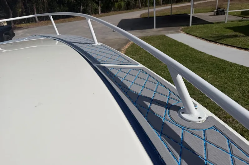 Slide: The Image of 2004 Jupiter 31 Cuddy boat deck with white railing and blue accents. - 32