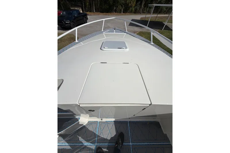 Slide: The Image of 2004 Jupiter 31 Cuddy boat deck with hatch, parked on pavement. - 33