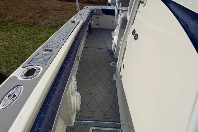 Slide: The Image of 2004 Jupiter 31 Cuddy boat interior with blue accents and diamond-patterned flooring. - 35