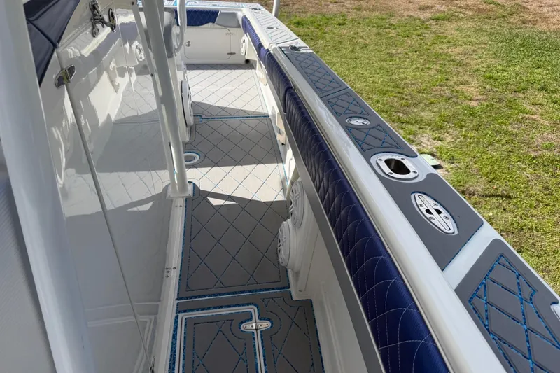 Slide: The Image of 2004 Jupiter 31 Cuddy boat interior with blue and gray accents, docked on grass. - 38