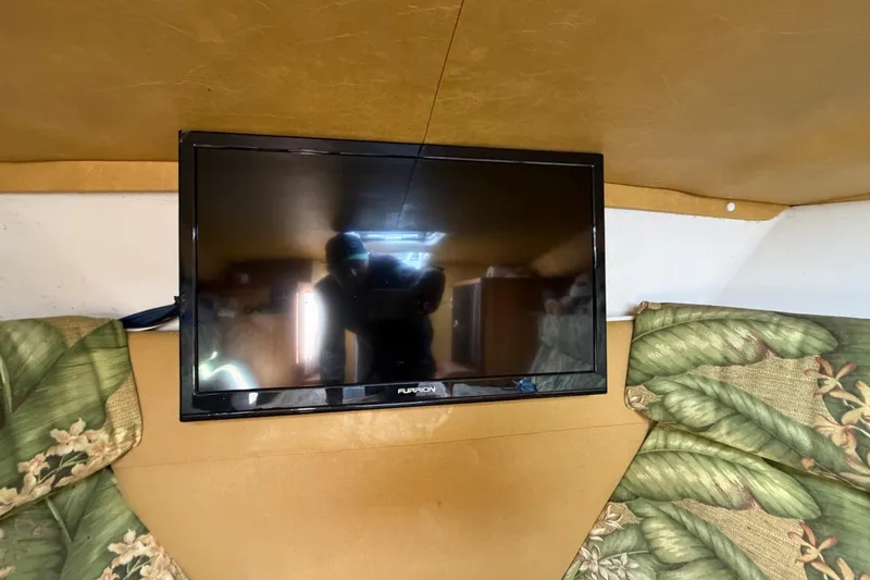 Slide: The Image of Flat-screen TV in 2004 Jupiter 31 Cuddy cabin with floral cushions. - 42