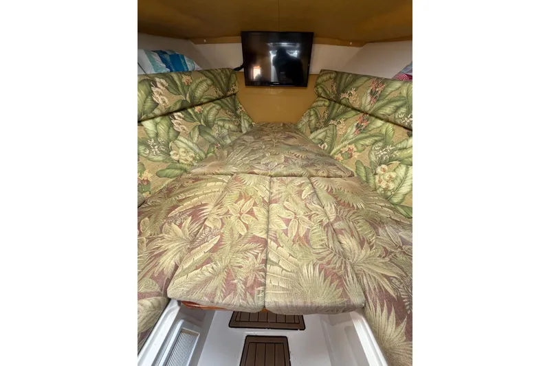 Slide: The Image of 2004 Jupiter 31 Cuddy cabin with floral-patterned cushions and a mounted TV. - 43