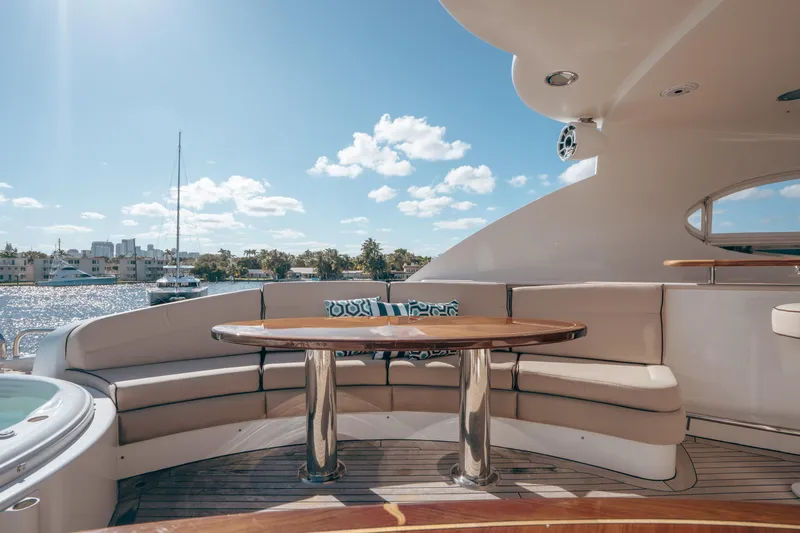 Slide: The Image of Luxurious 2004 Lazzara LY106 yacht deck with seating and table, overlooking serene waterfront. - 44