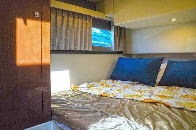 Slide: The Image of Cozy bedroom interior of 2020 Carver C40 yacht with sunlight and blue pillows. - 24