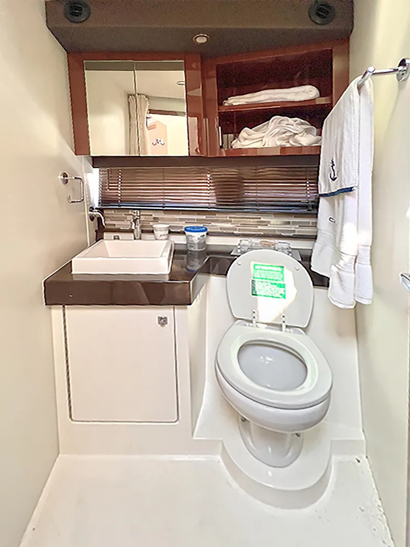 Slide: The Image of 2020 Carver C40 yacht bathroom with sink, toilet, and storage shelves. - 27