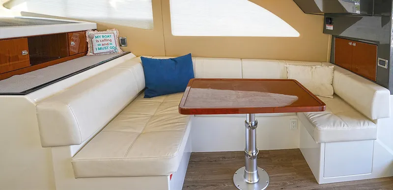 Slide: The Image of 2020 Carver C40 yacht interior with white leather seating and wooden table. - 18