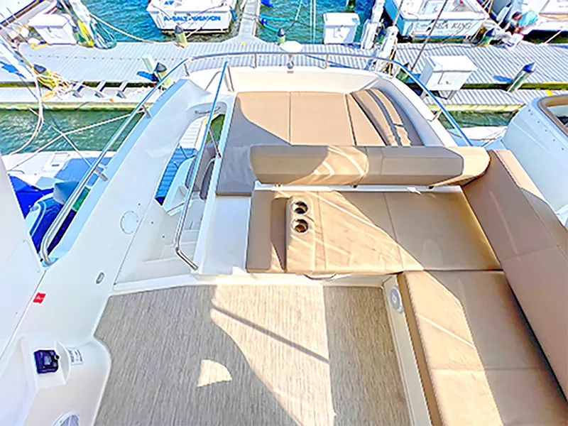 Slide: The Image of 2020 Carver C40 yacht deck with beige seating and cup holders at marina. - 4