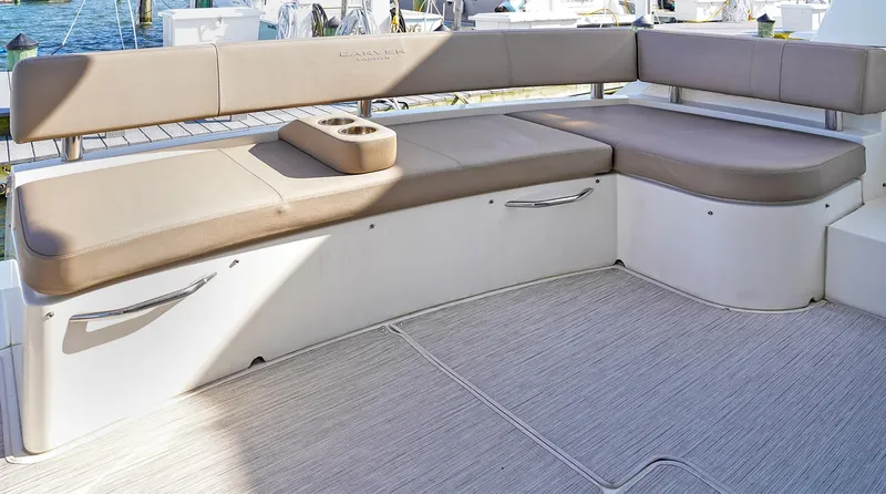 Slide: The Image of Luxurious seating area on a 2020 Carver C40 yacht, featuring beige cushions and storage. - 7