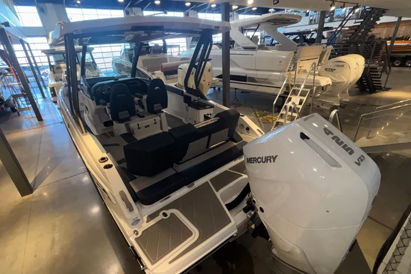 Slide: The Image of 2026 Monterey Elite 27 OB boat with Mercury engine in showroom setting. - 11