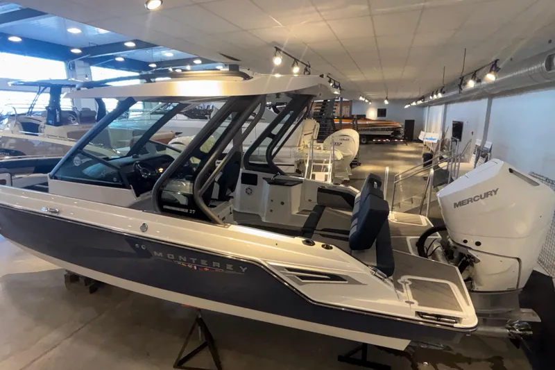 Slide: The Image of 2026 Monterey Elite 27 OB boat in showroom, featuring sleek design and Mercury outboard engine. - 12