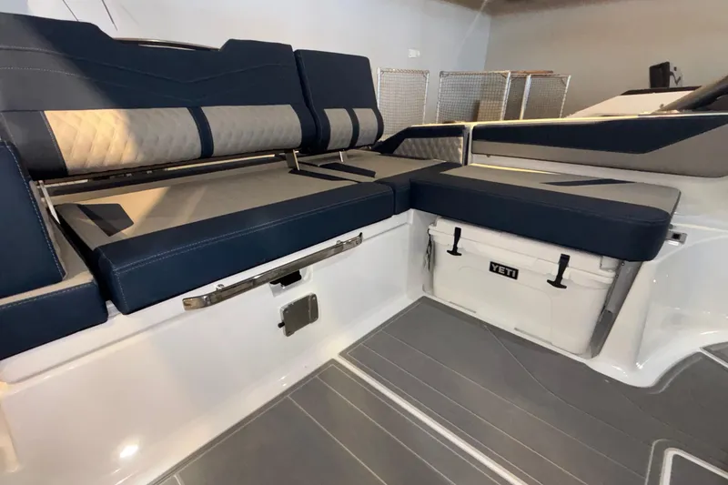 Slide: The Image of 2026 Monterey Elite 27 OB boat interior with cushioned seating and Yeti cooler. - 17
