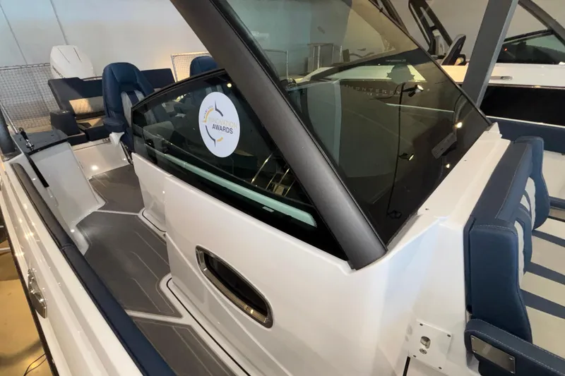 Slide: The Image of 2026 Monterey Elite 27 OB boat interior with award sticker, showcasing sleek design and seating. - 43