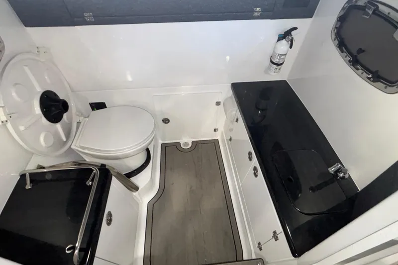 Slide: The Image of 2026 Monterey Elite 27 OB boat bathroom with toilet, sink, and fire extinguisher. - 53