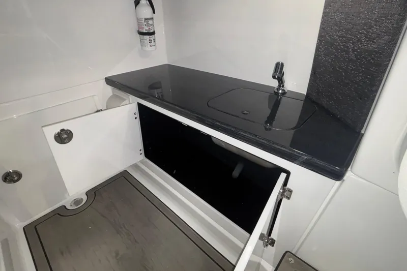 Slide: The Image of Interior of 2026 Monterey Elite 27 OB boat with sink and storage cabinets. - 58