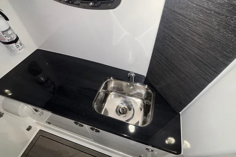 Slide: The Image of 2026 Monterey Elite 27 OB boat interior with sleek sink and countertop design. - 61