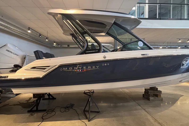 Slide: The Image of 2026 Monterey Elite 27 OB boat displayed indoors on stands. - 67