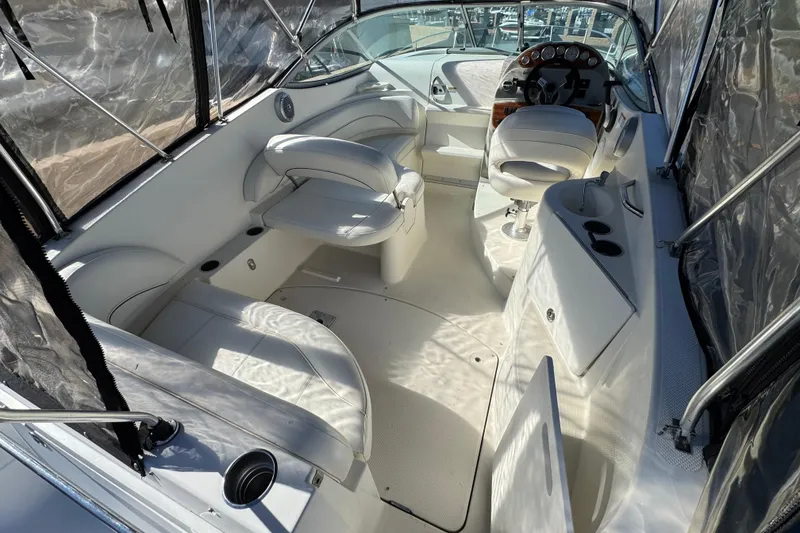 Slide: The Image of 2009 Bayliner 265 SB boat interior with white seating and steering console. - 10