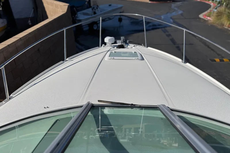 Slide: The Image of 2009 Bayliner 265 SB boat deck with railing and windshield, docked in a marina. - 11