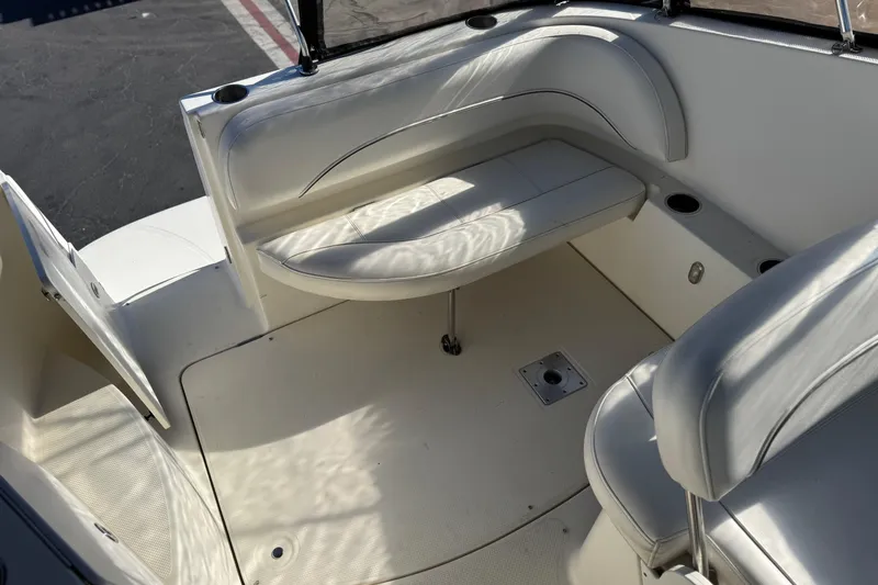Slide: The Image of 2009 Bayliner 265 SB boat interior with white seating and cup holders. - 12