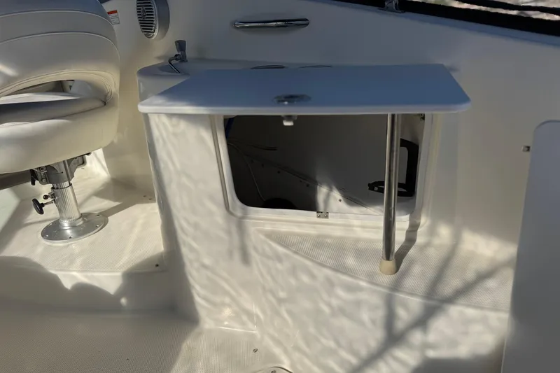Slide: The Image of 2009 Bayliner 265 SB interior with white seating and storage compartment. - 16