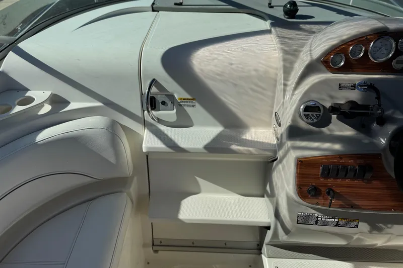 Slide: The Image of 2009 Bayliner 265 SB boat cockpit with white seating and control panel. - 21
