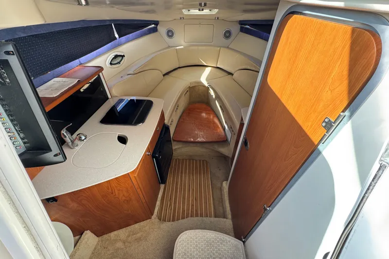 Slide: The Image of Interior of 2009 Bayliner 265 SB boat with kitchenette and seating area. - 23