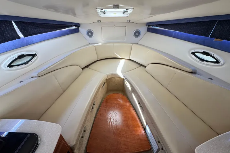 Slide: The Image of Interior of 2009 Bayliner 265 SB boat with beige seating and wood accents. - 24