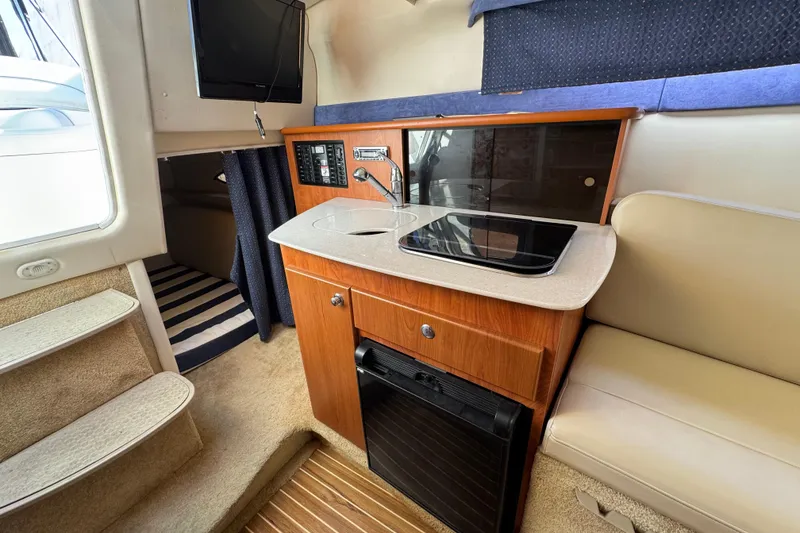 Slide: The Image of 2009 Bayliner 265 SB interior with kitchenette, TV, and seating area. - 25