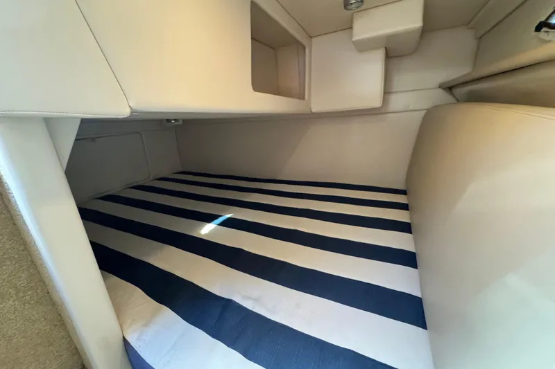 Slide: The Image of 2009 Bayliner 265 SB cabin interior with striped bedding. - 27