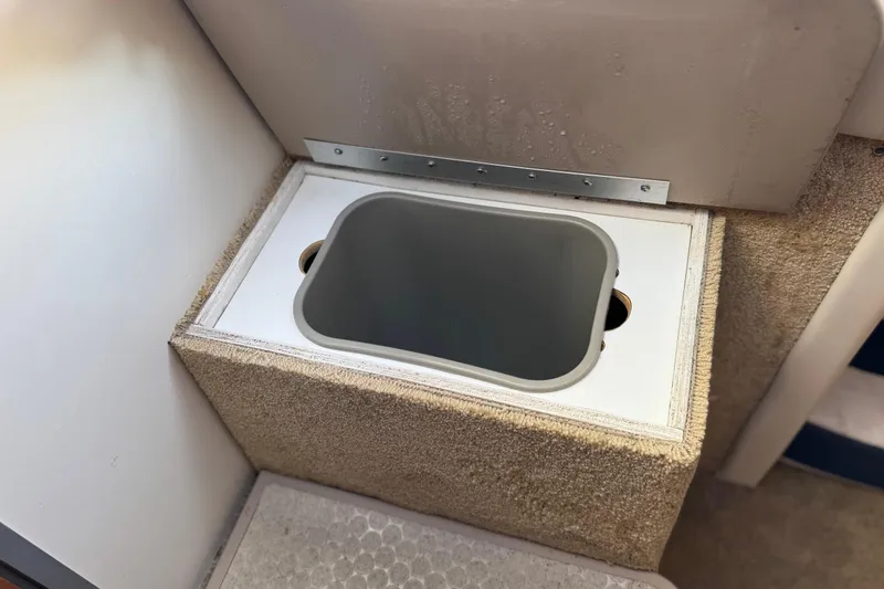 Slide: The Image of 2009 Bayliner 265 SB interior storage compartment with beige carpeted finish. - 28