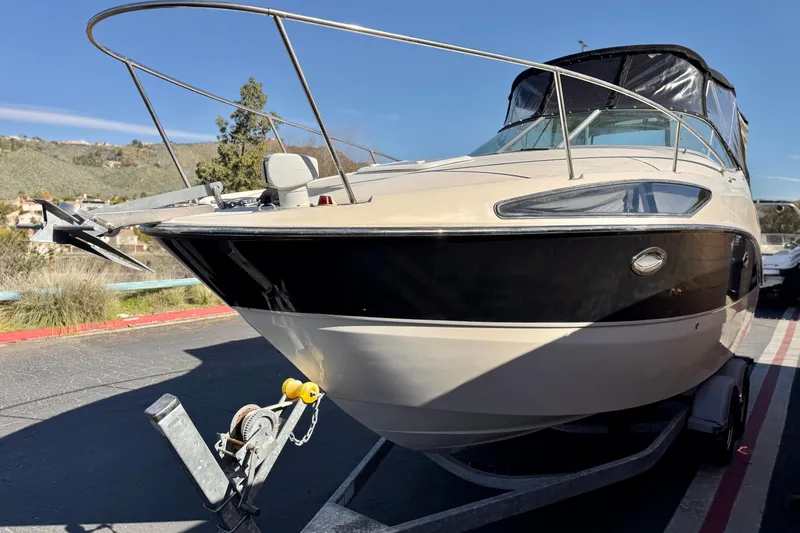 Slide: The Image of 2009 Bayliner 265 SB boat on trailer, parked outdoors, sunny day. - 3