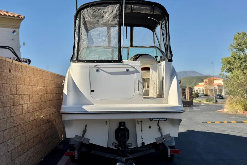 Slide: The Image of 2009 Bayliner 265 SB boat with covered cockpit, parked outdoors. - 4