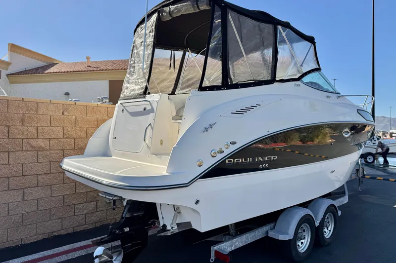 Slide: The Image of 2009 Bayliner 265 SB boat on trailer, featuring sleek design and protective canopy. - 5