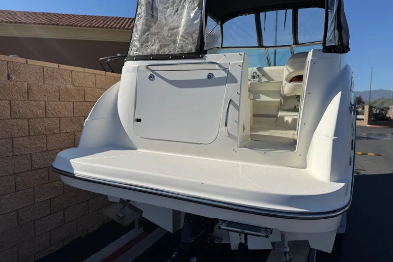 Slide: The Image of 2009 Bayliner 265 SB boat, rear view with open cabin door, parked outdoors. - 6