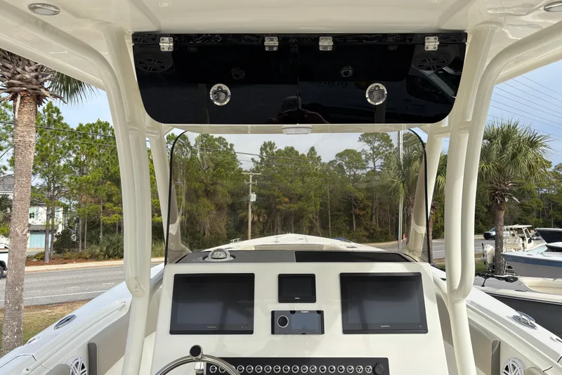 Slide: The Image of 2026 Key West 263 FS boat dashboard with dual screens and steering wheel, surrounded by trees. - 14
