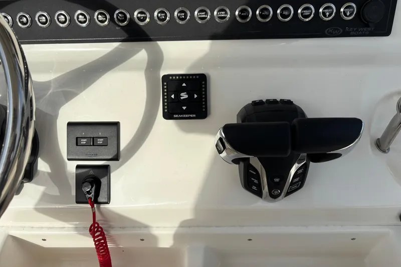Slide: The Image of Control panel of 2026 Key West 263 FS boat with steering and throttle controls. - 17