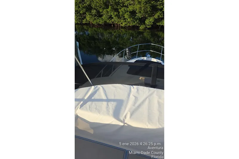 Slide: The Image of 2023 Regal 38 FXO boat docked near lush greenery in Miami-Dade County, Florida. - 10