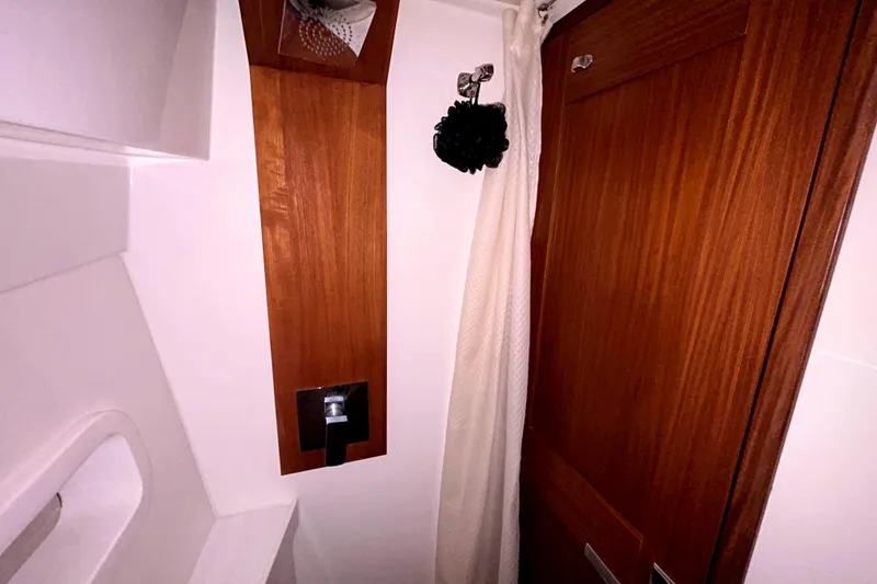 Slide: The Image of 2023 Regal 38 FXO bathroom interior with wooden accents and shower curtain. - 101