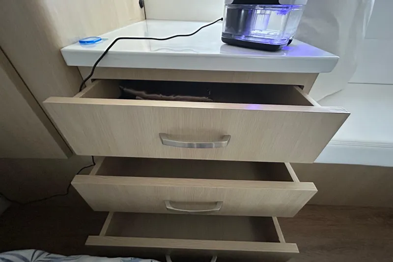 Slide: The Image of Open wooden drawers in a 2023 Regal 38 FXO boat interior. - 108