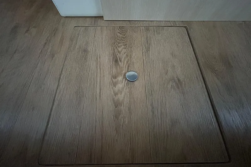 Slide: The Image of Wooden hatch on 2023 Regal 38 FXO boat floor with metal handle. - 110