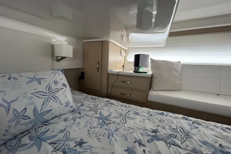 Slide: The Image of Cozy cabin interior of 2023 Regal 38 FXO with starfish-patterned bedding. - 114