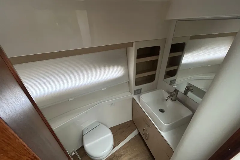 Slide: The Image of 2023 Regal 38 FXO yacht bathroom with modern sink, toilet, and mirror. - 117