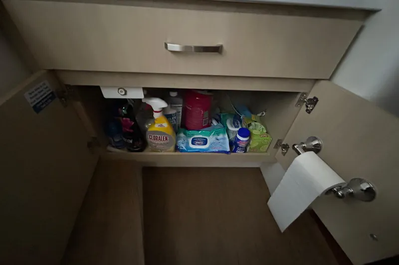 Slide: The Image of Cabinet storage on 2023 Regal 38 FXO boat with cleaning supplies and toilet paper. - 124