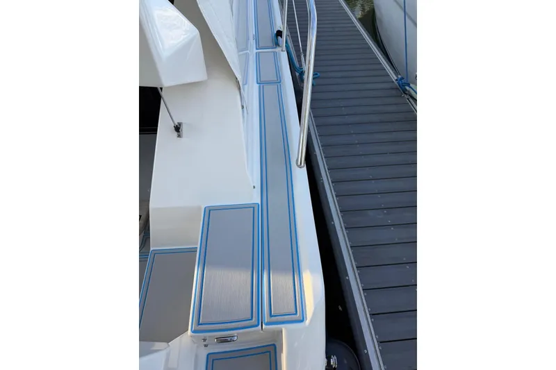 Slide: The Image of 2023 Regal 38 FXO yacht docked beside a wooden pier, showcasing sleek design. - 41