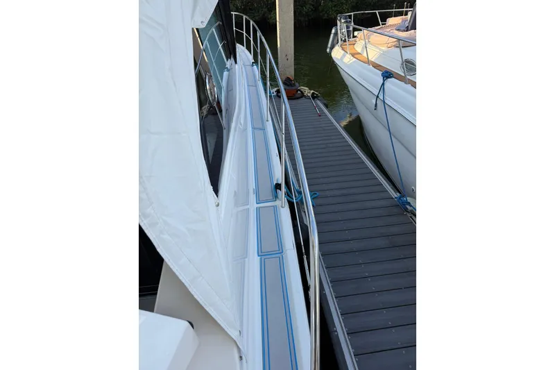 Slide: The Image of 2023 Regal 38 FXO boat deck with blue accents, docked on calm water. - 42