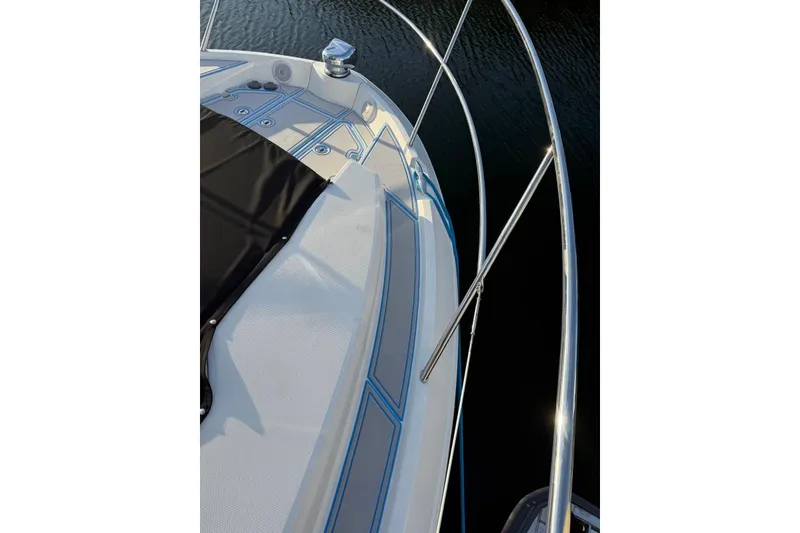 Slide: The Image of 2023 Regal 38 FXO yacht docked beside a wooden pier, showcasing sleek design and railing. - 46