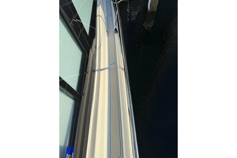 Slide: The Image of 2023 Regal 38 FXO boat side view, docked on calm water. - 51