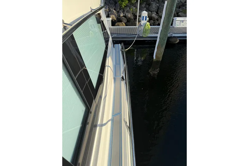 Slide: The Image of 2023 Regal 38 FXO boat with black cover on deck, docked in marina. - 52