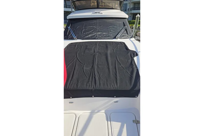 Slide: The Image of Triple outboard engines on a 2023 Regal 38 FXO boat docked at a marina. - 54