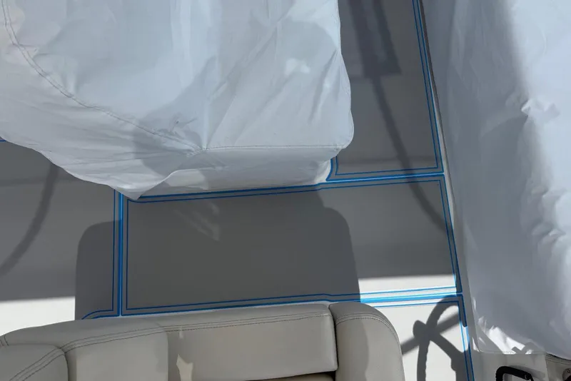 Slide: The Image of 2023 Regal 38 FXO boat interior with covered seating and blue-trimmed flooring. - 8